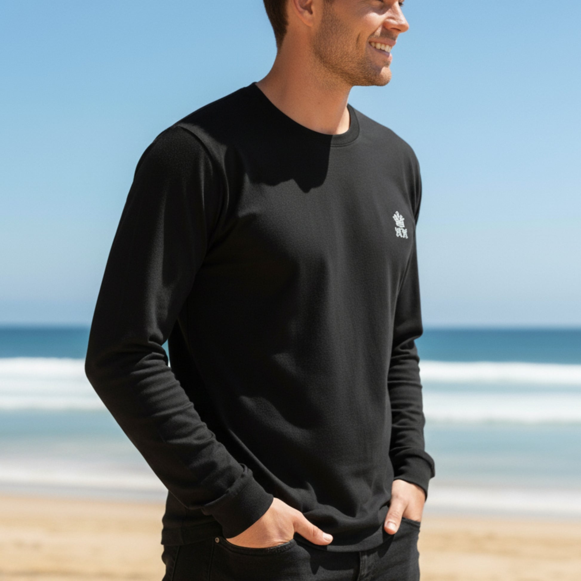 Man wearing a  Dew 100% Cotton black long-sleeve shirt with a logo on a beach