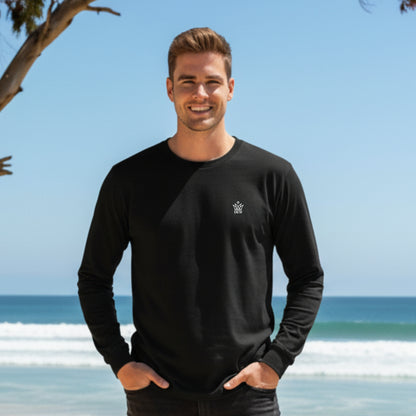 Man wearing a  Dew 100% Cotton black long-sleeve shirt with a logo on a beach