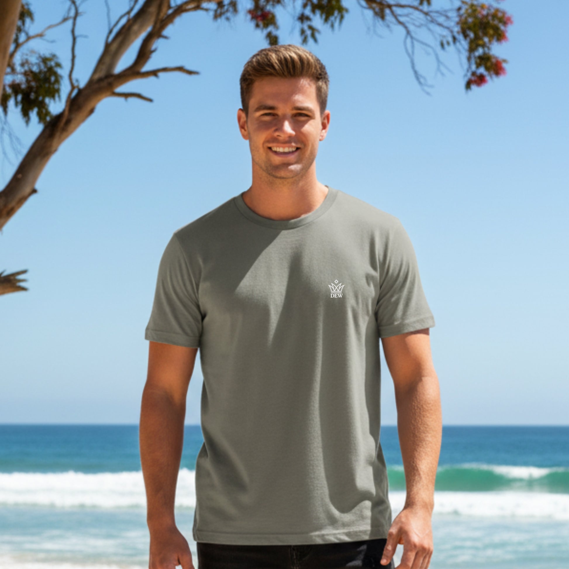 Man wearing a Dew 100% Cotton Rock Ash t-shirt with a logo on a beach