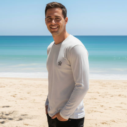 Man wearing a Dew 100 % cotton sea gray long-sleeve shirt with a logo on a beach