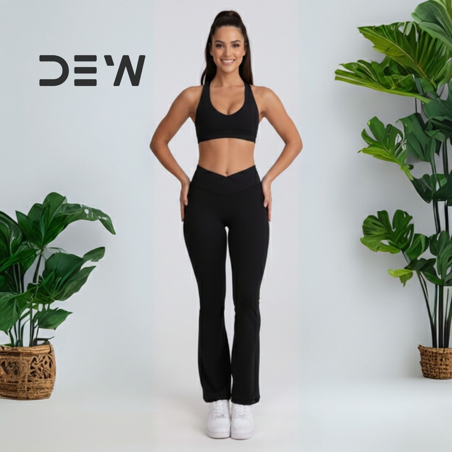 Woman wearing black seamless sports bra and Flow Fit Flare leggings. Studio shot highlighting high-waist and bell-bottom design.