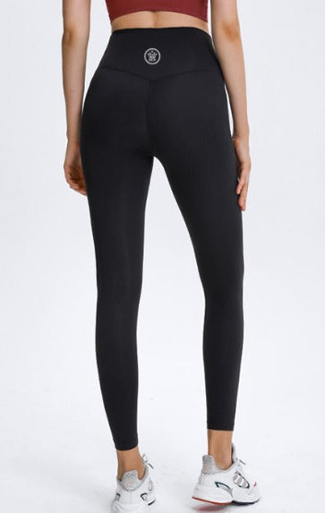 Person wearing Dew Core fit high waisted leggings black with Dew Active logo on a white background 