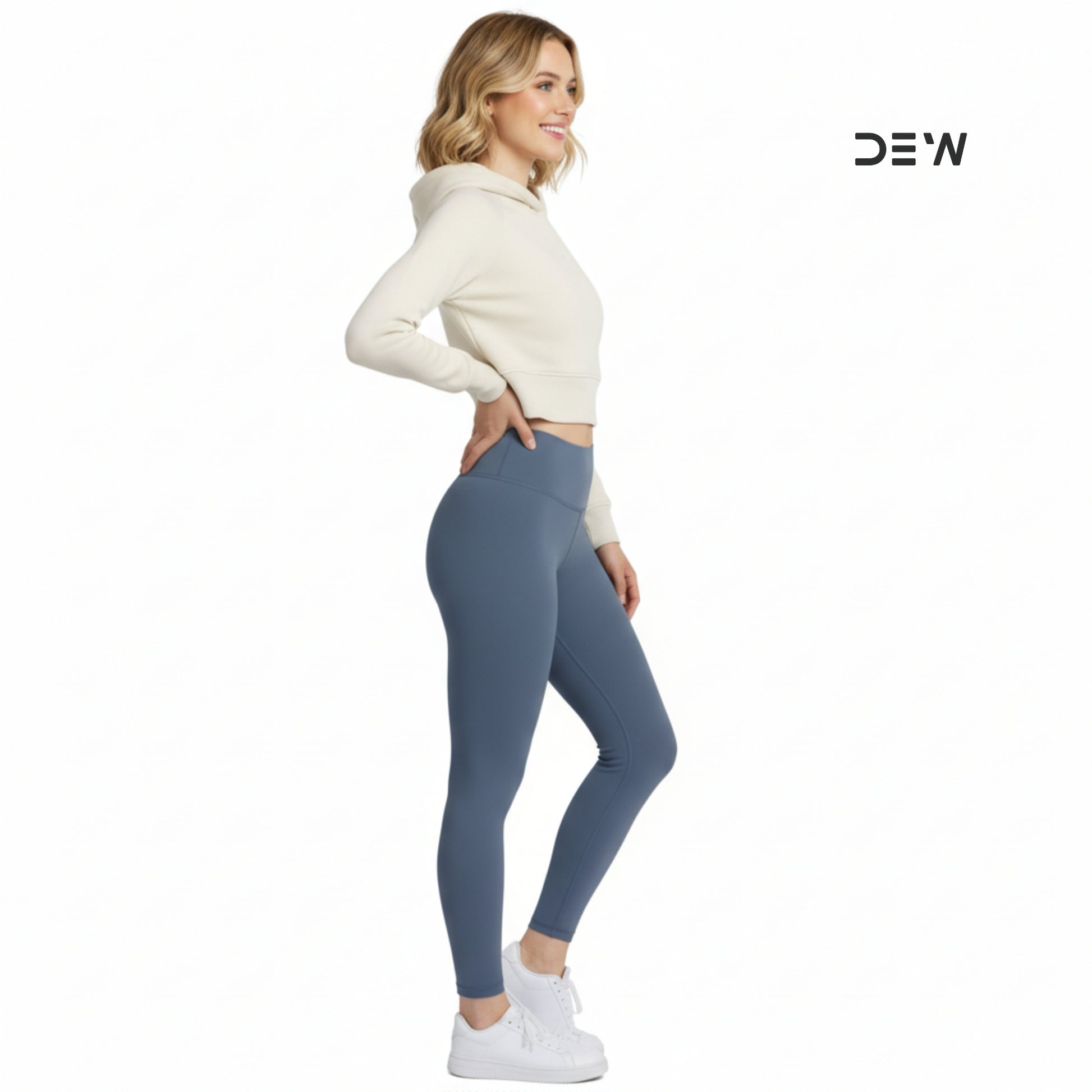 Woman wearing a cream sweater and Dew Core fit high waited leggings ocean mist on a white background with 'DEW' branding.
