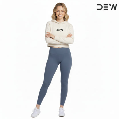 Woman wearing a beige hoodie and Dew Core fit high waited leggings ocean mist with 'DEW' branding on a white background