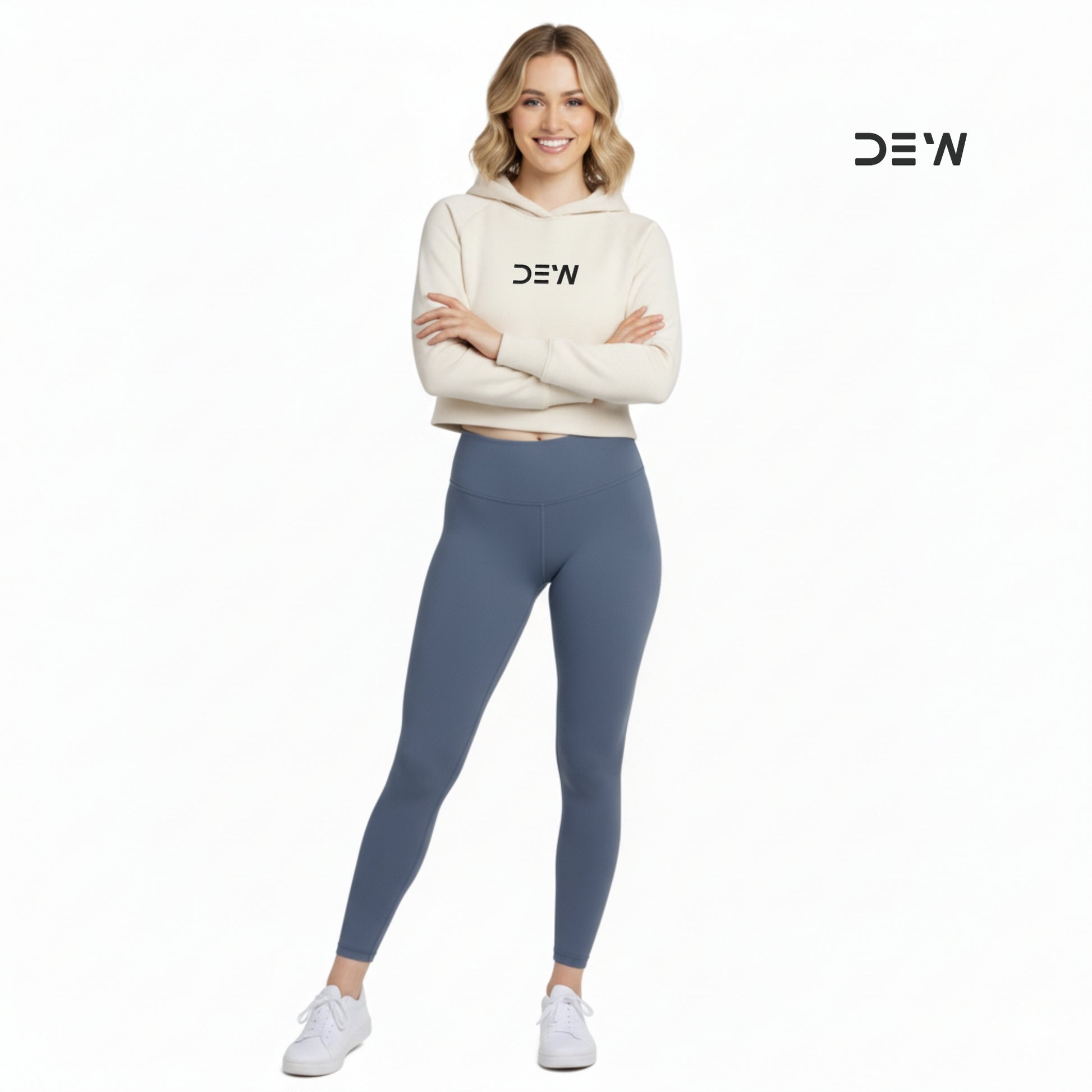 Woman wearing a beige hoodie and Dew Core fit high waited leggings ocean mist with 'DEW' branding on a white background