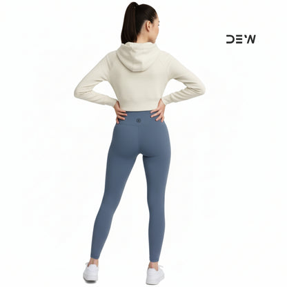 Person wearing a cream hoodie and Dew Core fit high waited leggings ocean mist  on a white background with 'DEW' branding.