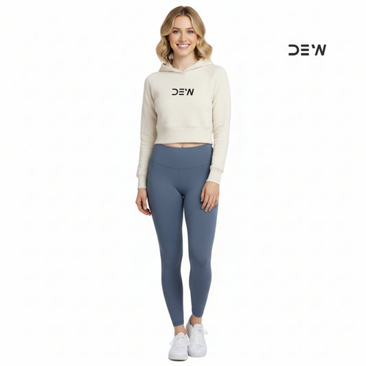 Woman wearing a beige hoodie and Dew ocean mist leggings with 'DEW' branding on a white background