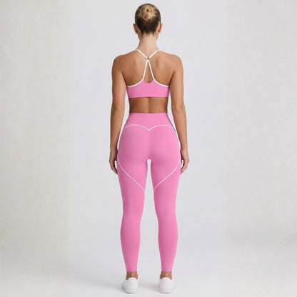 Person wearing a pink Dew Elevate Bra -sports bra and leggings set on a plain background