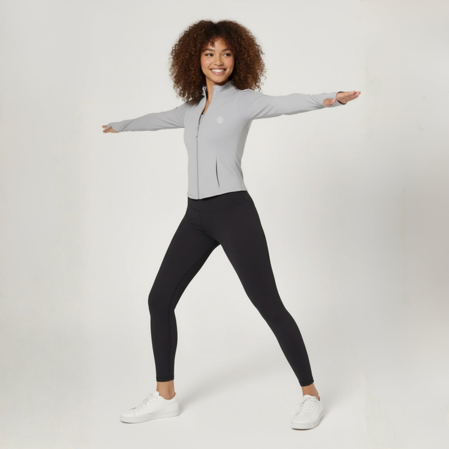 Woman wearing a Dew Grey Flex UPF50+ Performance Jacket  zip-up jacket and black leggings on a white background