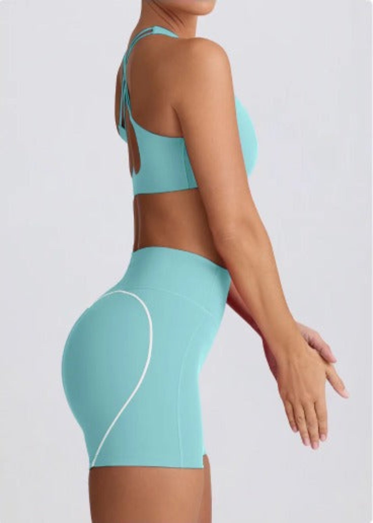Person wearing a Dew Mint heart flex bra and shorts on a light gray background