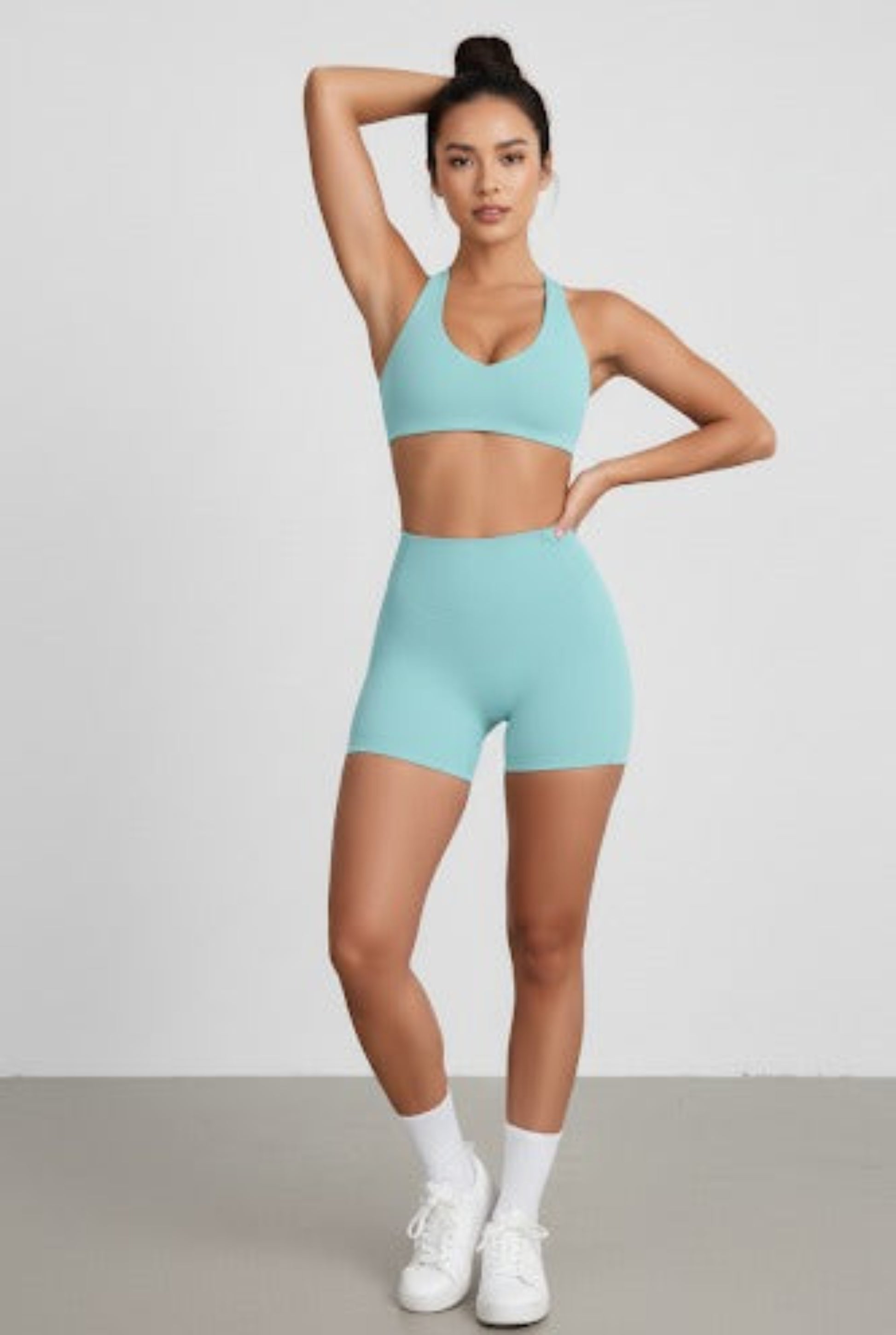 Woman wearing a light blue athletic outfit on a plain background