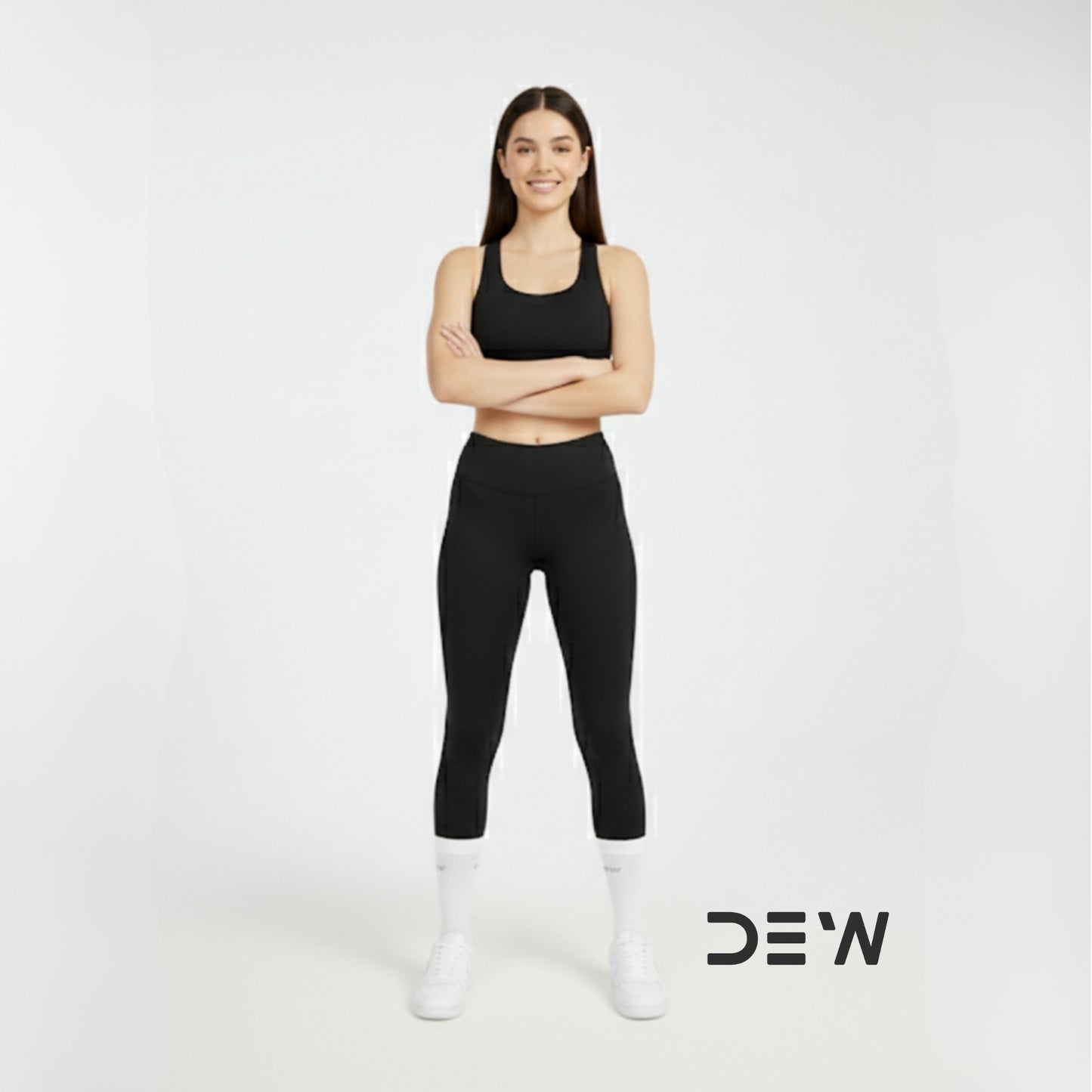 Woman wearing black athletic wear and Dew white crew socks with 'DEW' logo on a white background