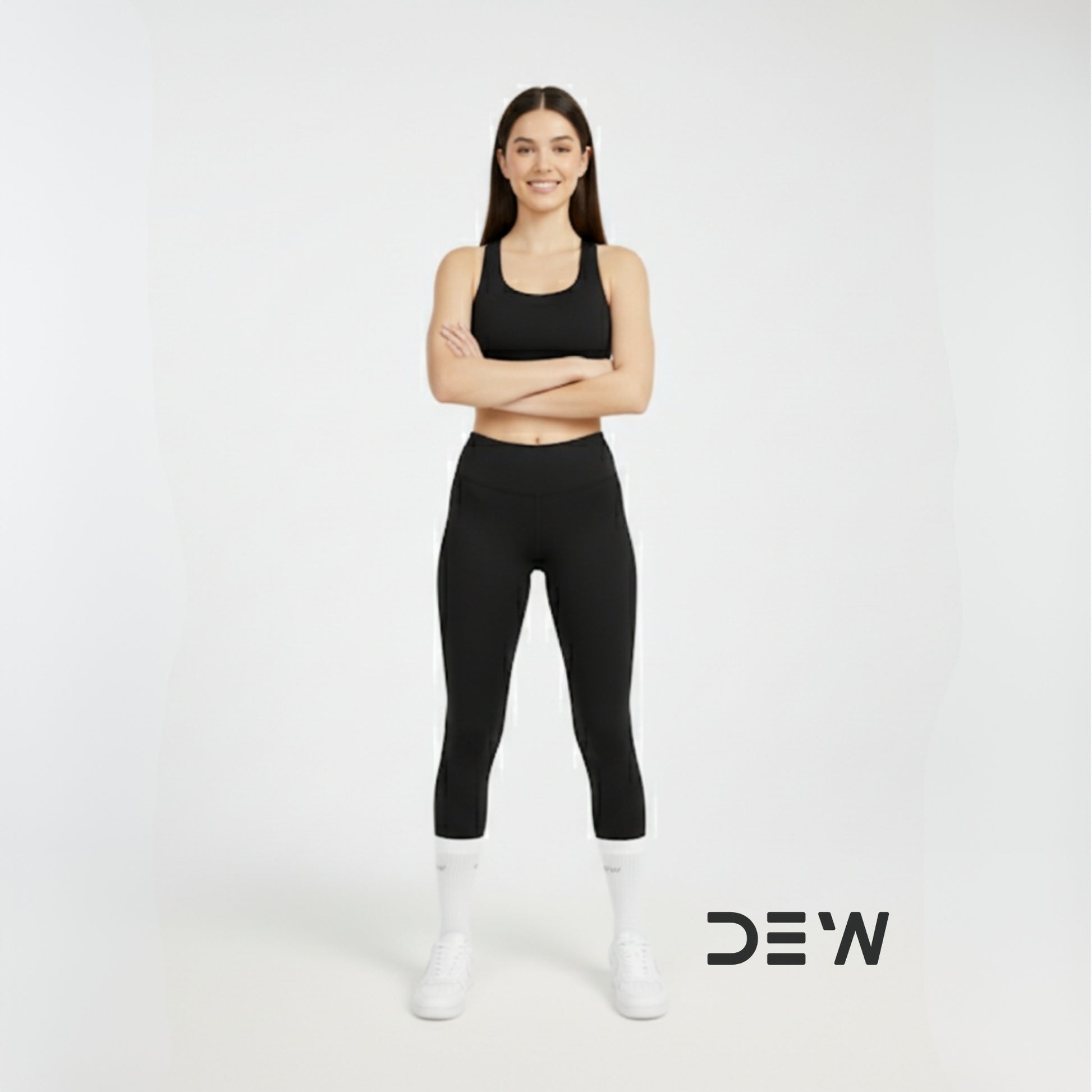 Woman wearing black athletic wear and Dew white crew socks with 'DEW' logo on a white background