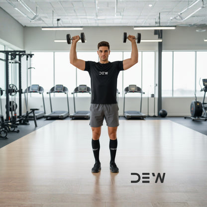 Man exercising with dumbbells in a gym setting, wearing a black 'DEW' t-shirt and Dew bamboo socks.