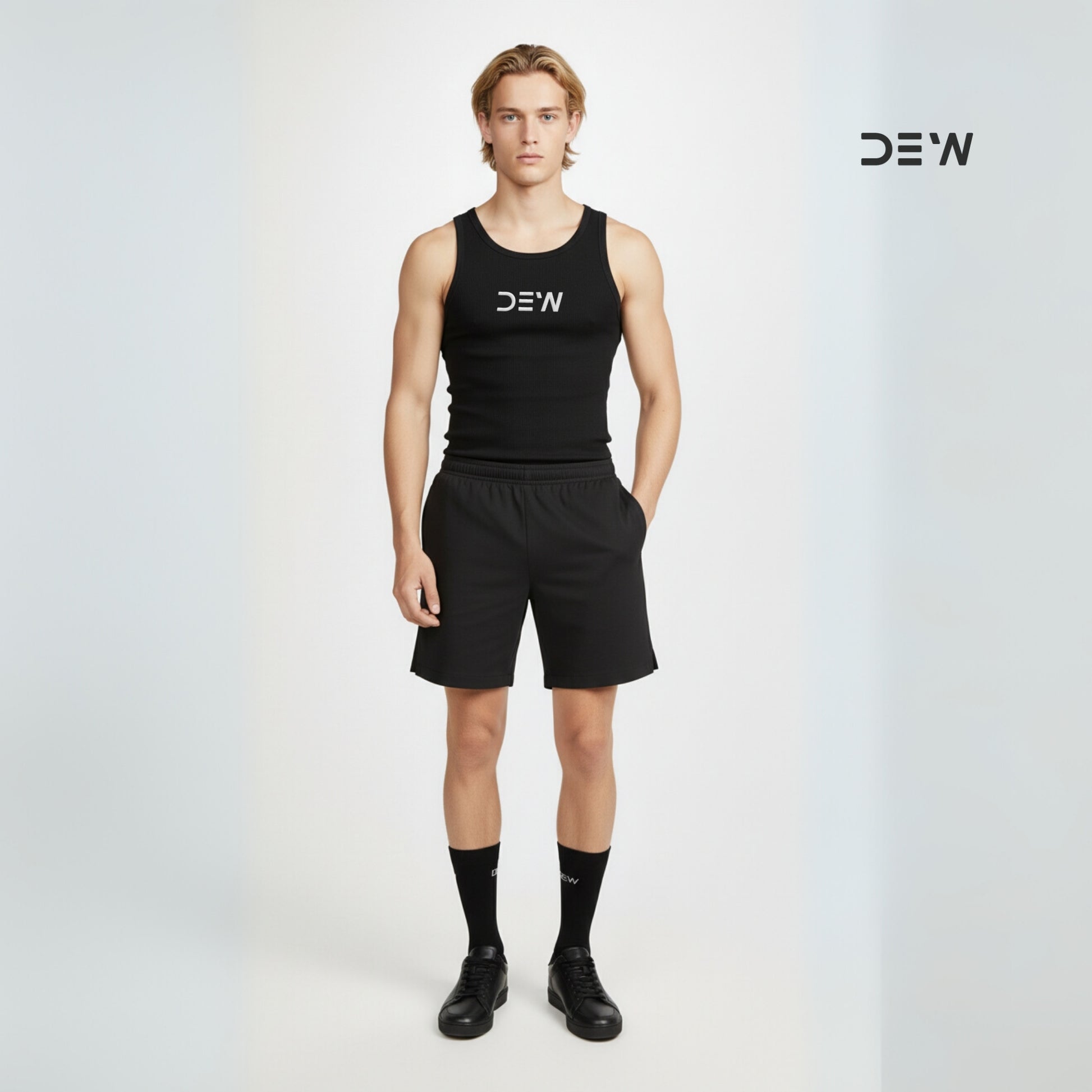 Person wearing a black tank top, shorts and Dew crew socks with 'DEW' branding on a light gray background.
