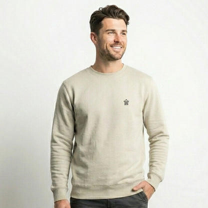 Man wearing a Dew cream crewneck jumper with a small embroidered dew logo on a white background