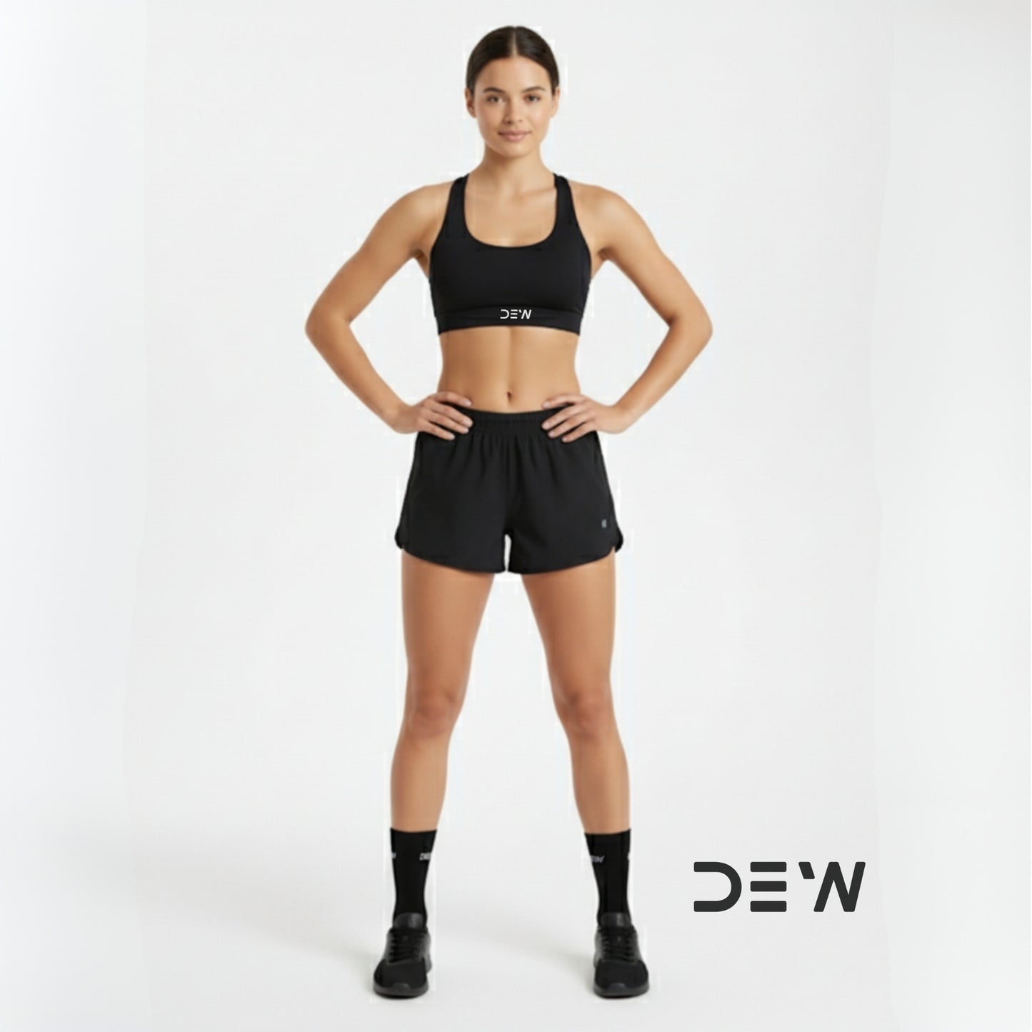 Woman wearing black sports bra and shorts and Dew crew socks with 'DEW' branding on a white background