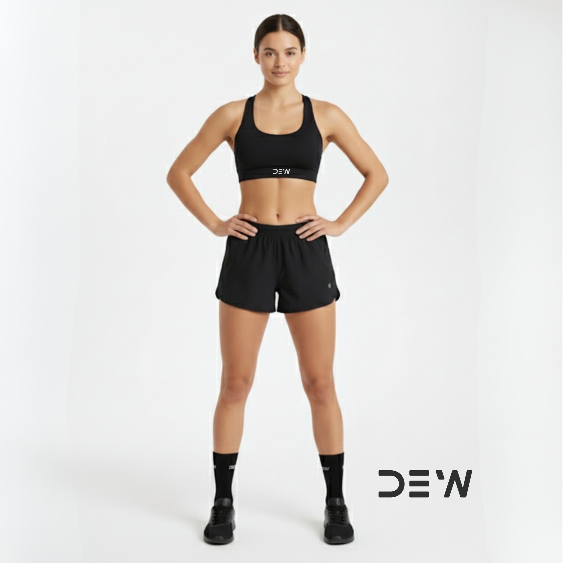 Woman wearing black sports bra and shorts and Dew crew socks with 'DEW' branding on a white background