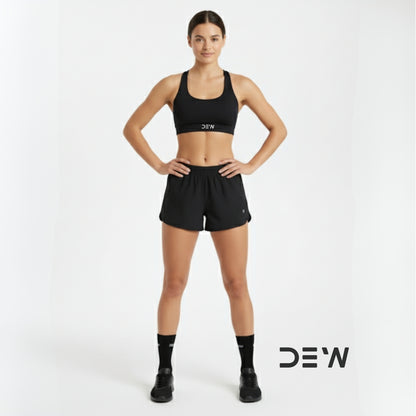 Woman wearing black sports bra and shorts and Dew crew socks with 'DEW' branding on a white background