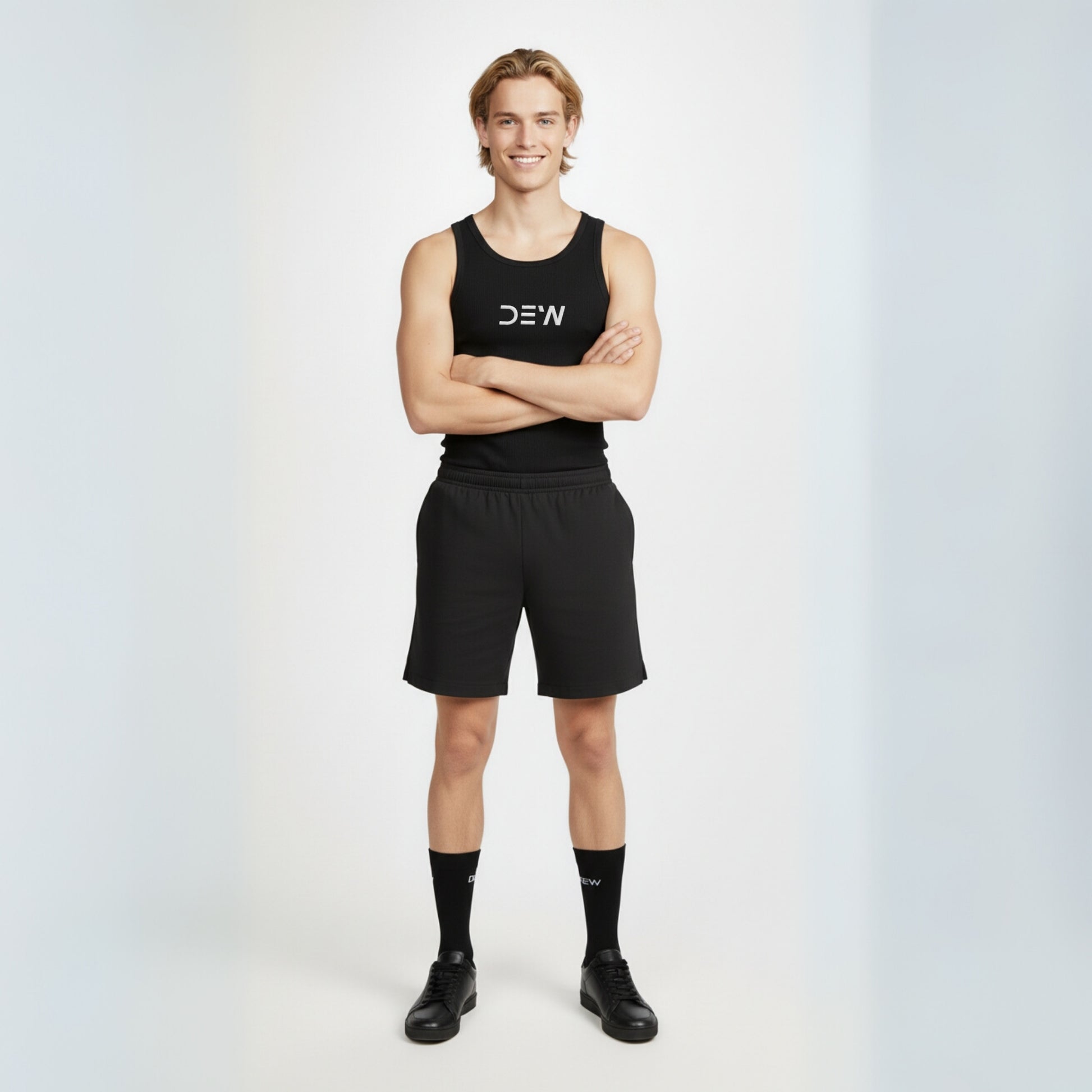Person wearing a black tank top, shorts and Dew crew socks with 'DEW' branding on a white background