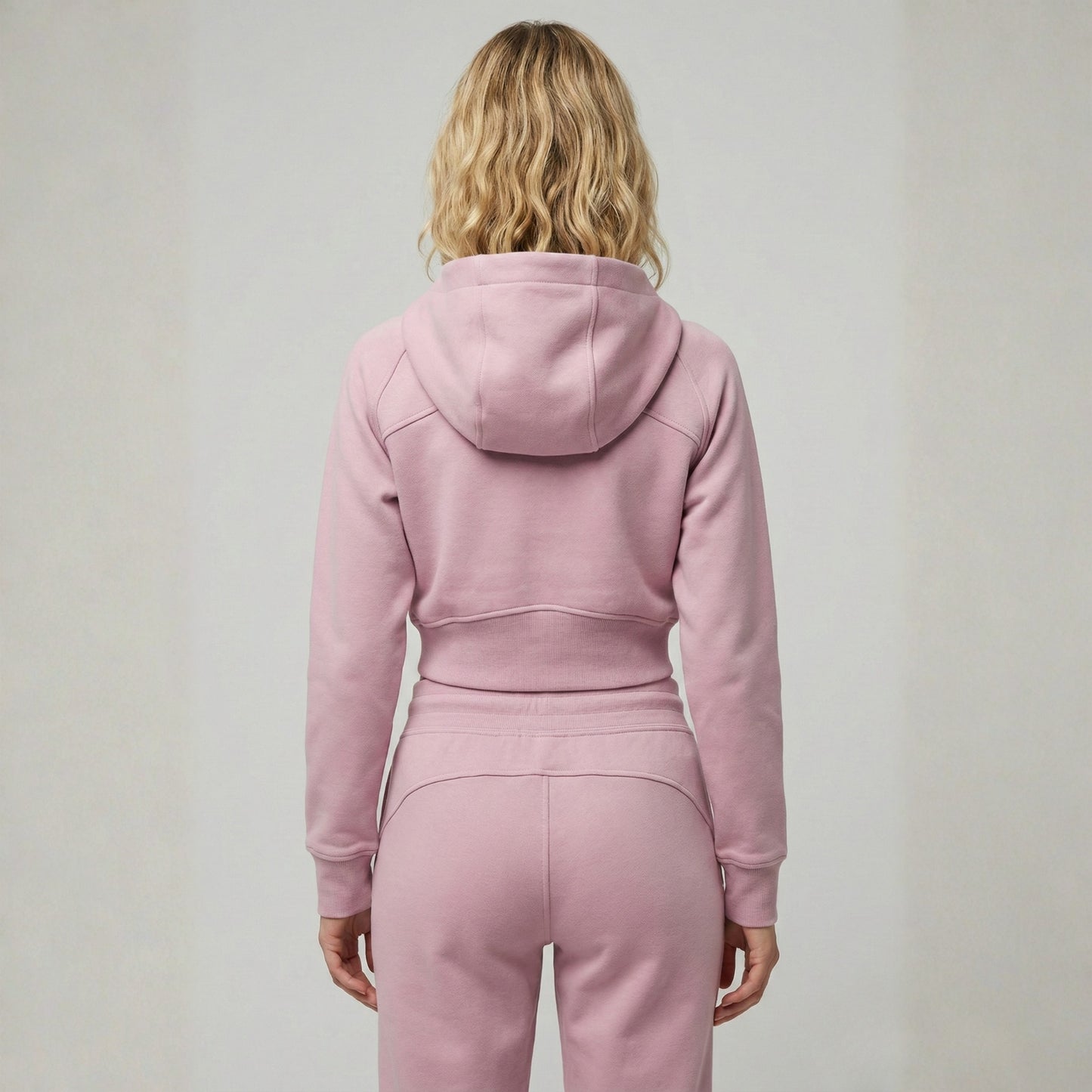 Woman wearing Dew crop zip jacket in pink back view