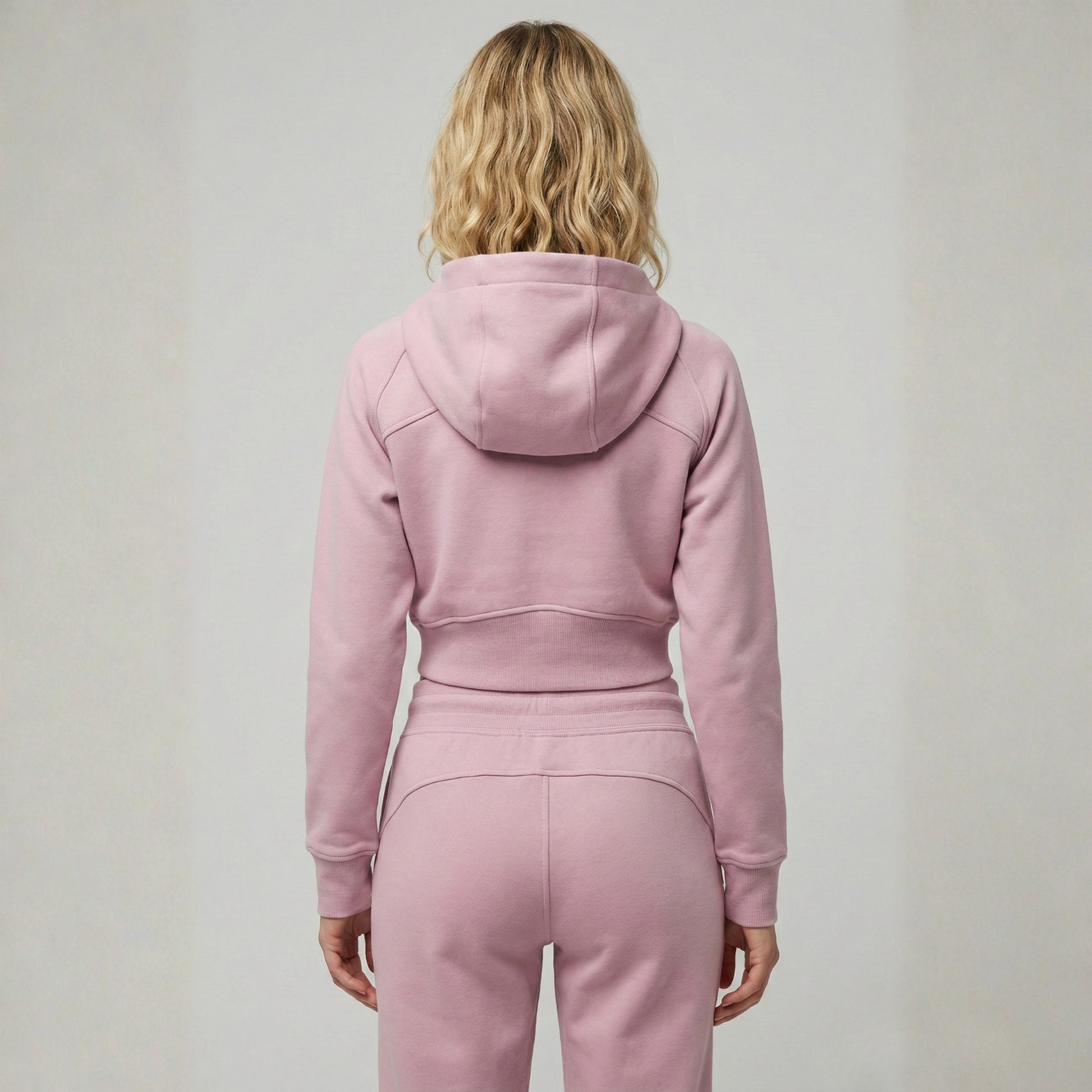 Woman wearing Dew crop zip jacket in pink back view