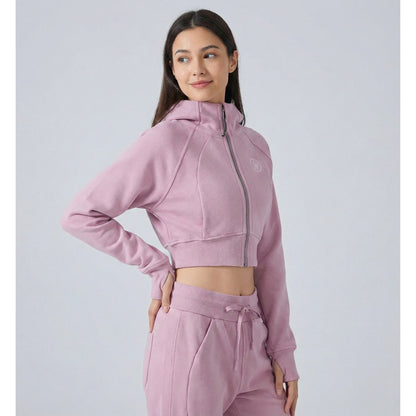 woman wearing Dew crop zip jacket pink in plain background