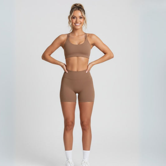 Woman wearing a dew coco sports bra and dew curve shorts set on a light gray background