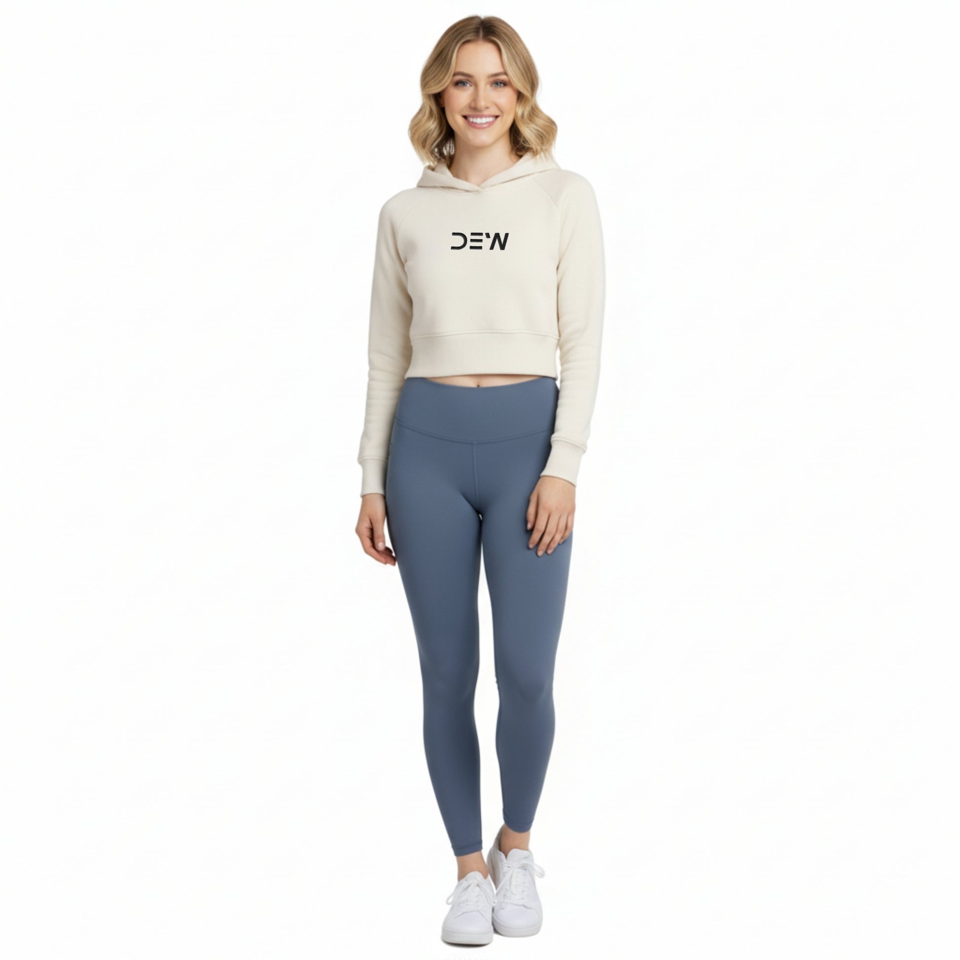 Woman wearing a beige cropped hoodie and Dew ocean mist leggings on a white background