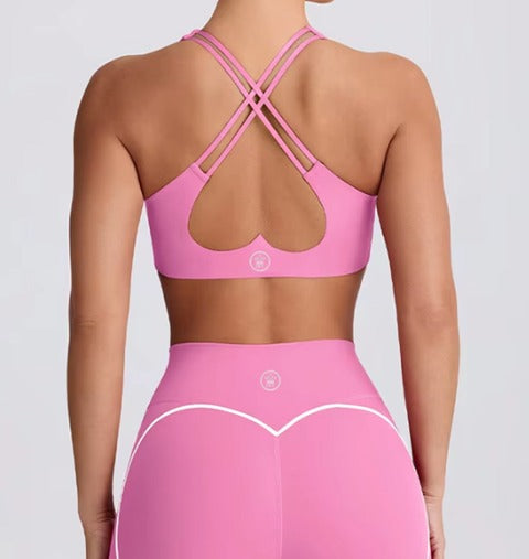 Pink sports bra and leggings set on a plain background