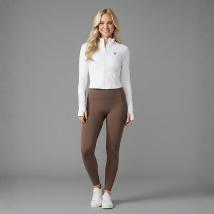 Woman wearing a white Flex UPF50+ Performance Jacket and brown leggings on a gray background