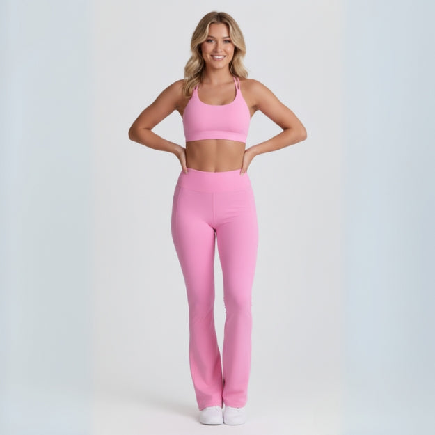 Woman wearing full pink seamless sports bra and high-waist seamless leggings set. Studio shot highlighting the flattering, comfortable fit.