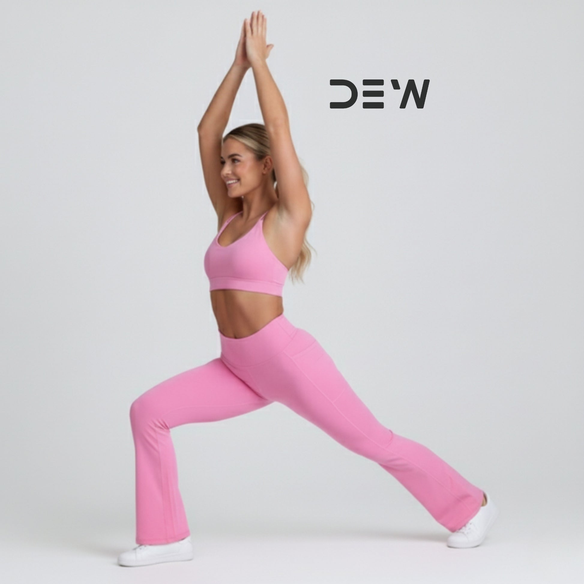 Woman in pink seamless sports bra and Flow Fit Flare leggings performing Warrior pose. Image highlights flexibility and active fit.