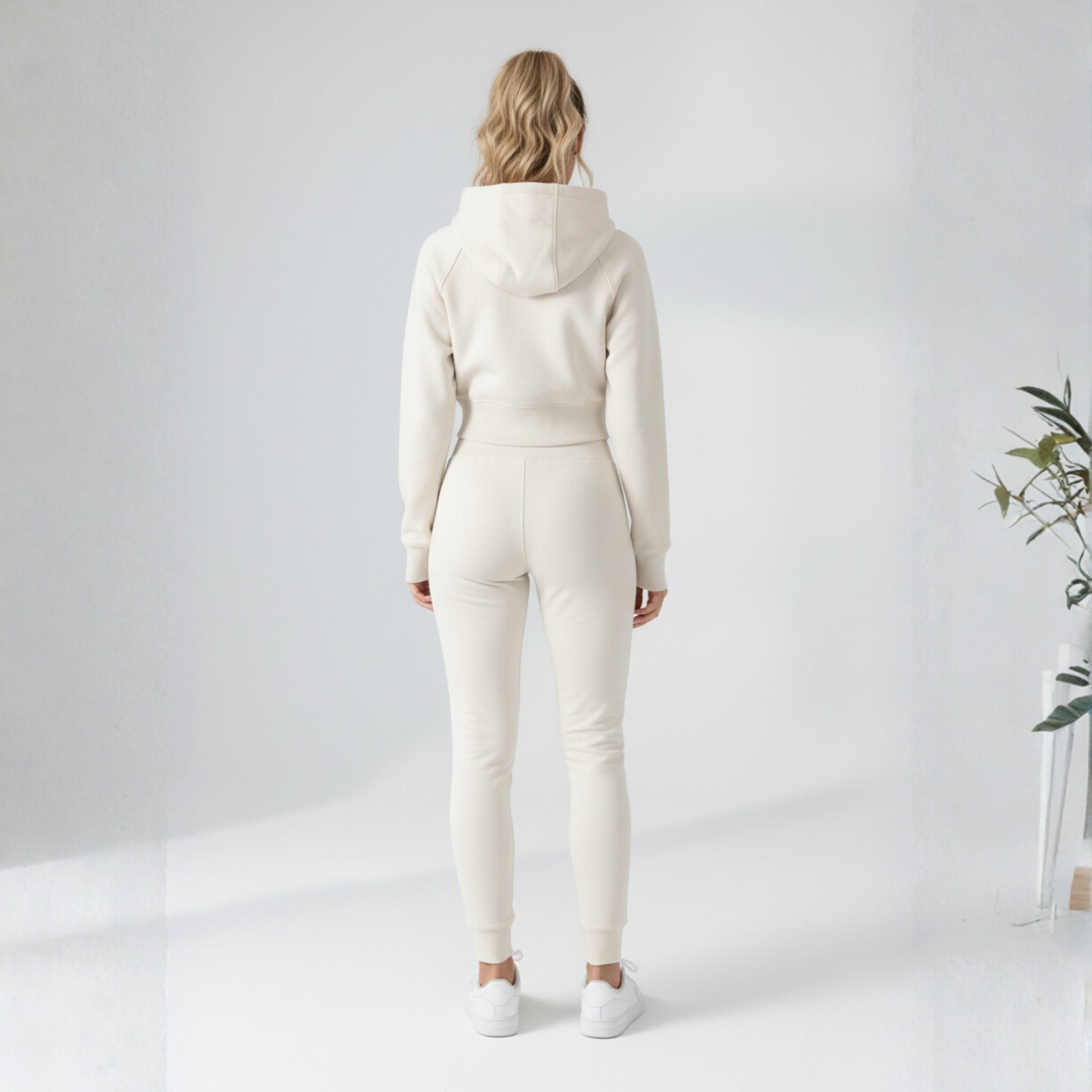 Person wearing a cream-colored Dew Women's Premium Crop Zip Jacket against a white background