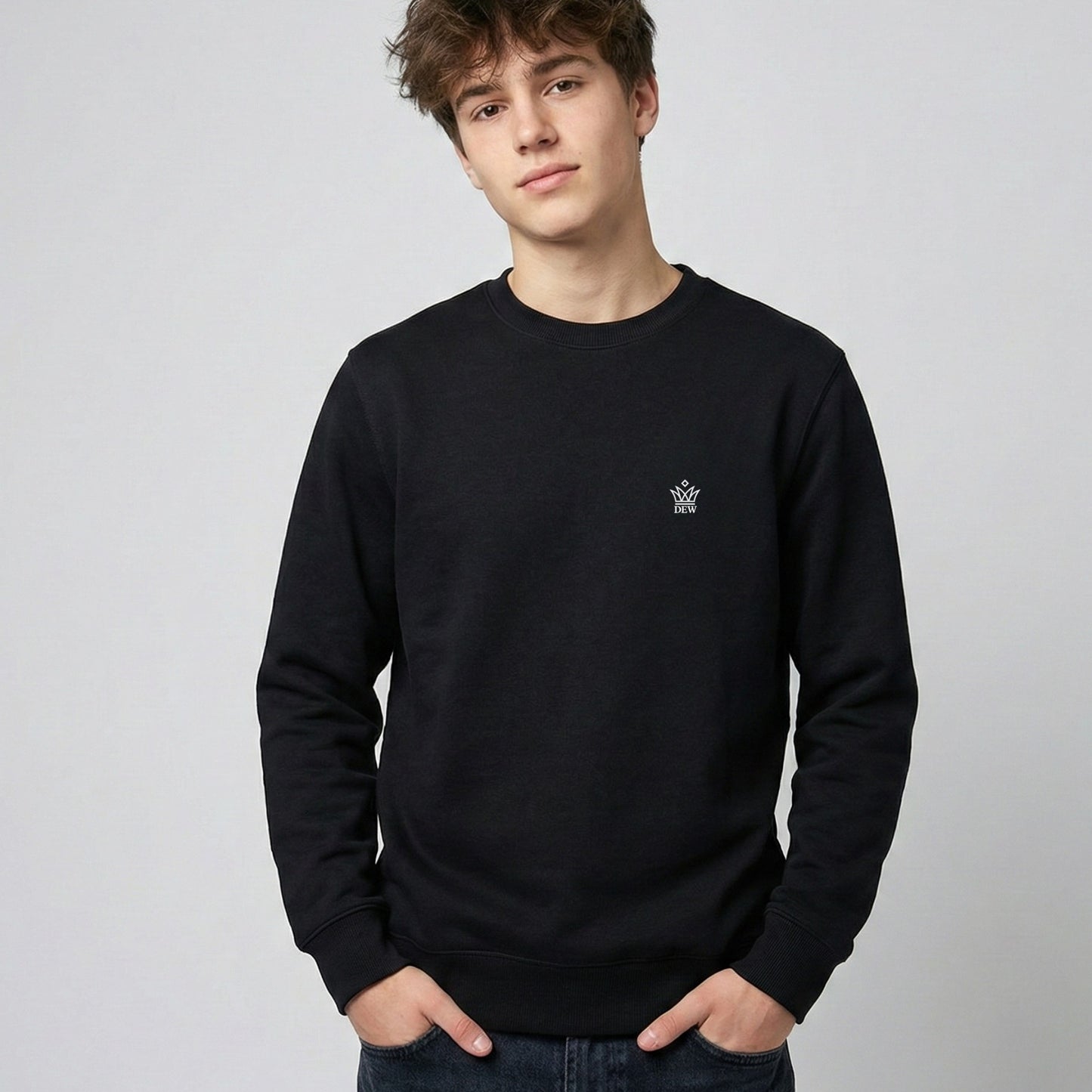 Person wearing a black Dew Classic Jumper with a small logo on a plain background