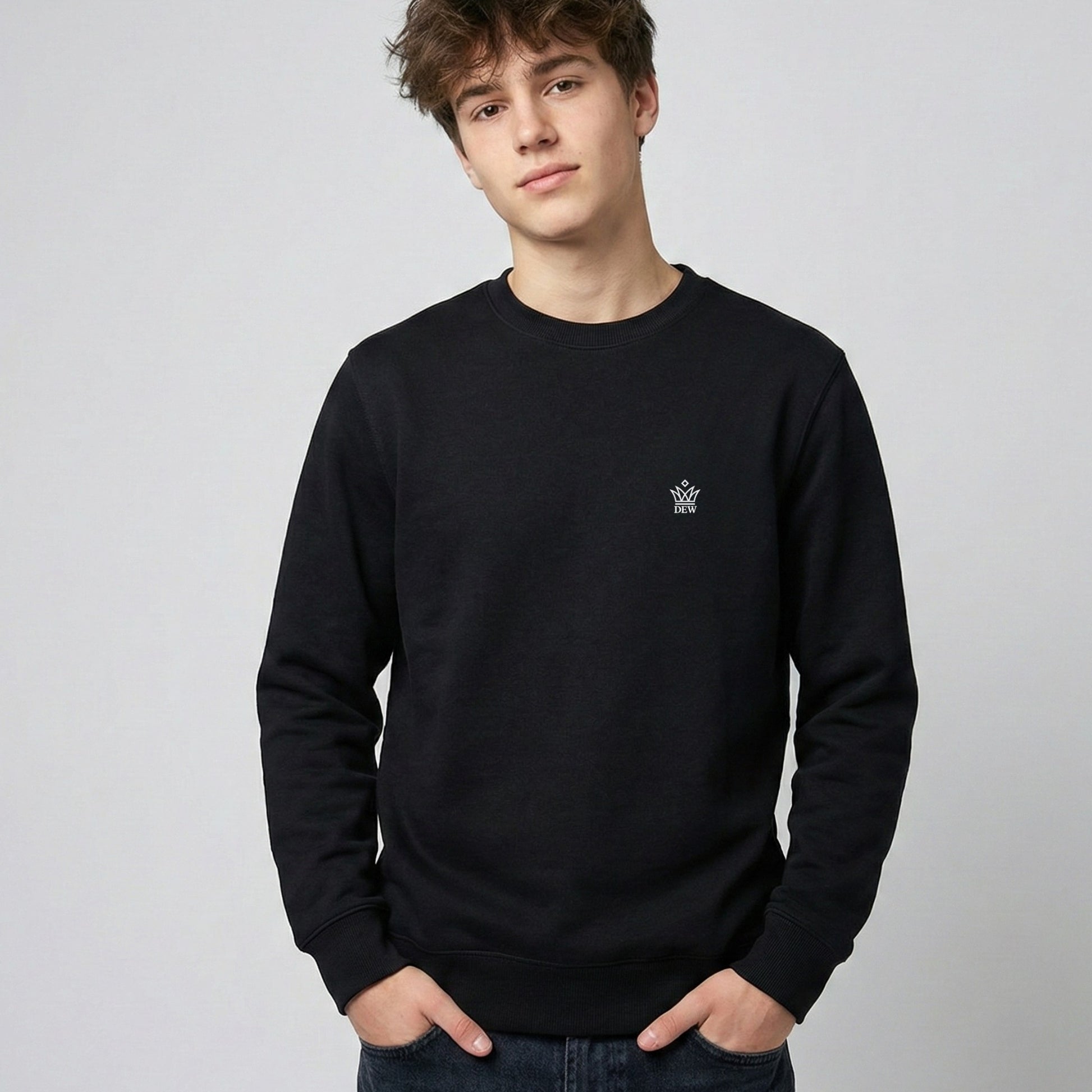 Person wearing a black Dew Classic Jumper with a small logo on a plain background