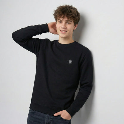Person wearing a  black Dew Classic Jumper with a small logo, standing against a plain background