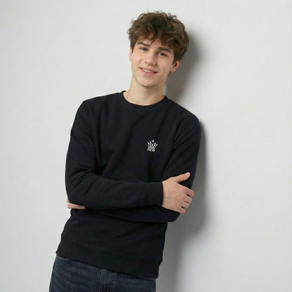 Person wearing a black Dew Classic Jumper with a logo against a light gray background