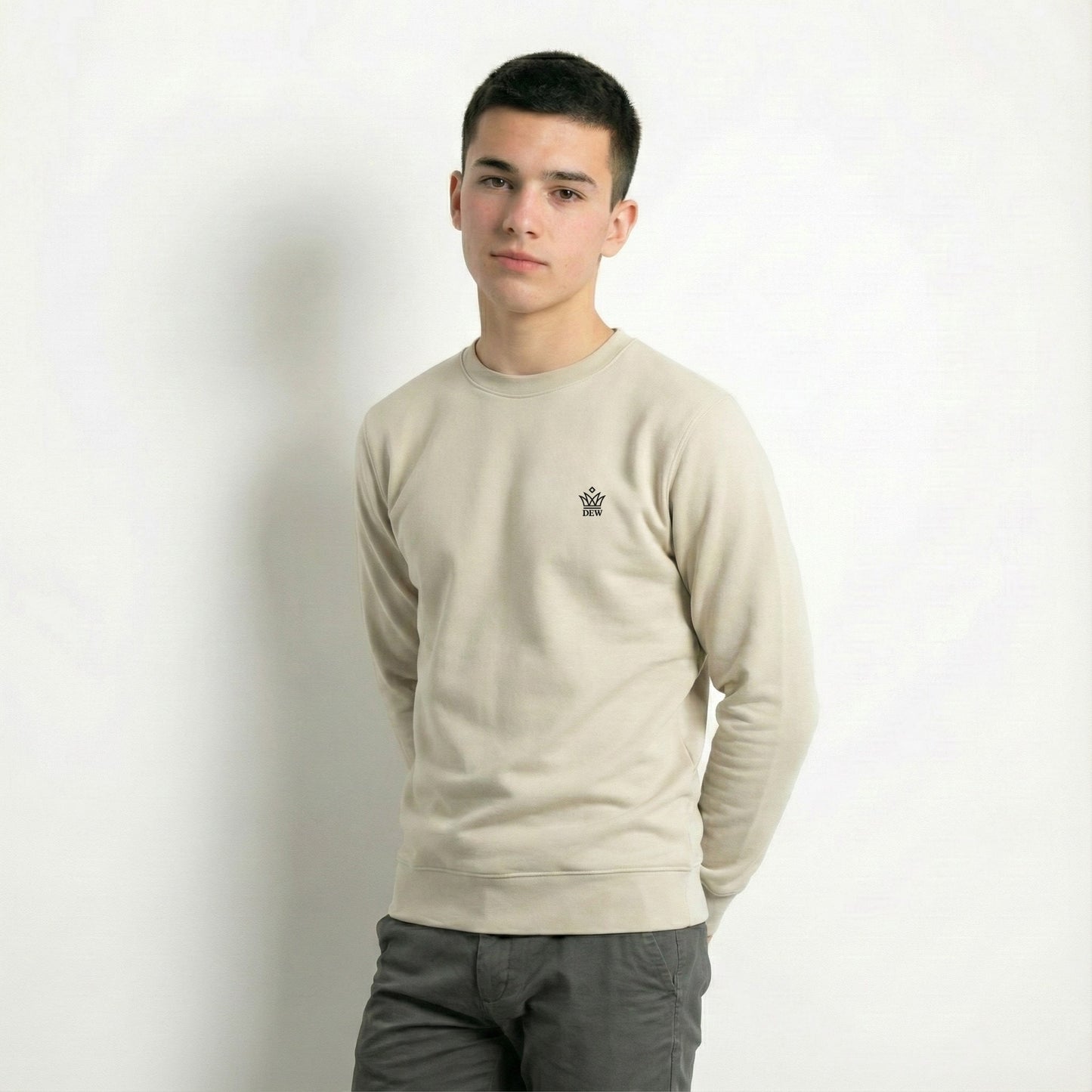 Person wearing a caramel Dew jumper with a small logo on a plain background