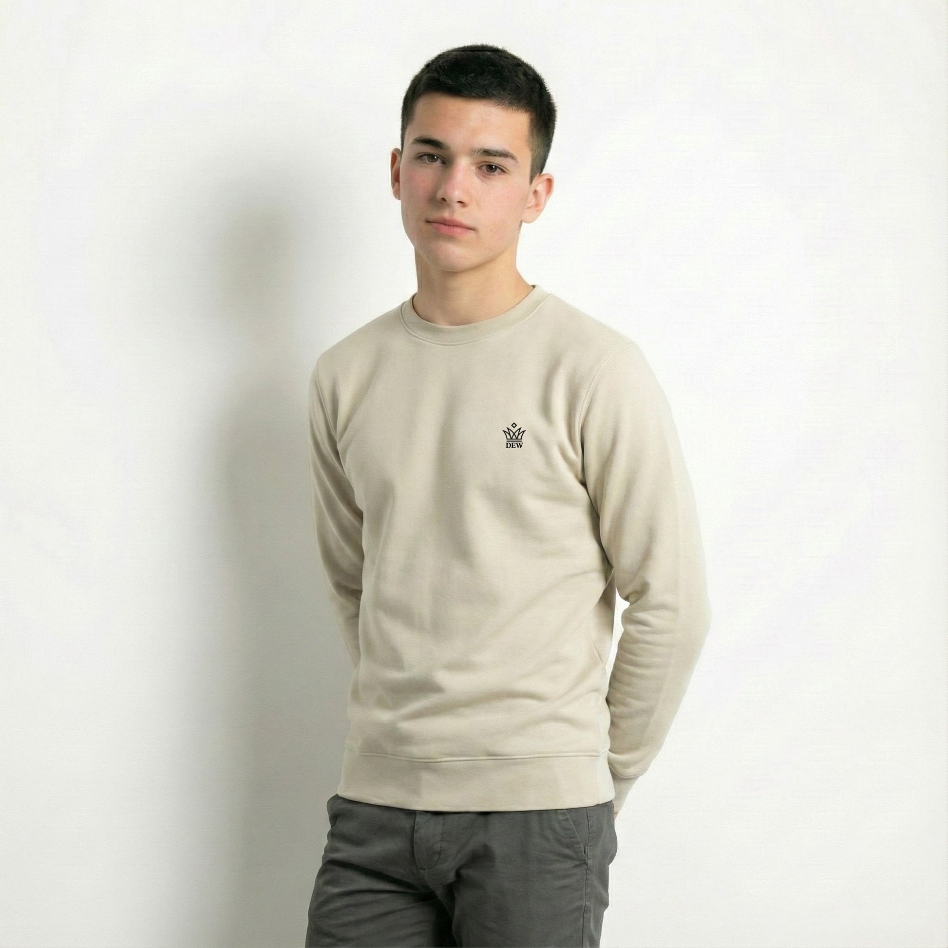 Person wearing a caramel Dew jumper with a small logo on a plain background