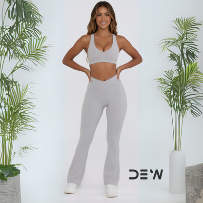 Detail view of the elegant bell-bottom flare hem on the grey activewear fabric.