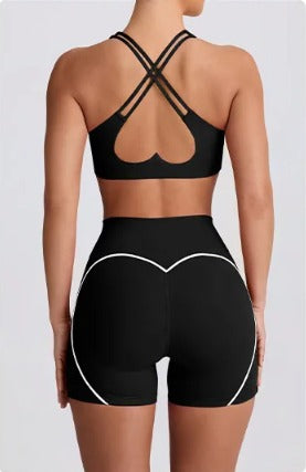 Black Dew sports bra and Dew curve shorts set with heart design on a white background