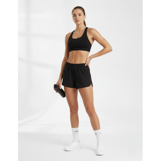 Australian woman in black seamless sports bra, black activewear shorts, and white DEW crew socks. Full fitness outfit.