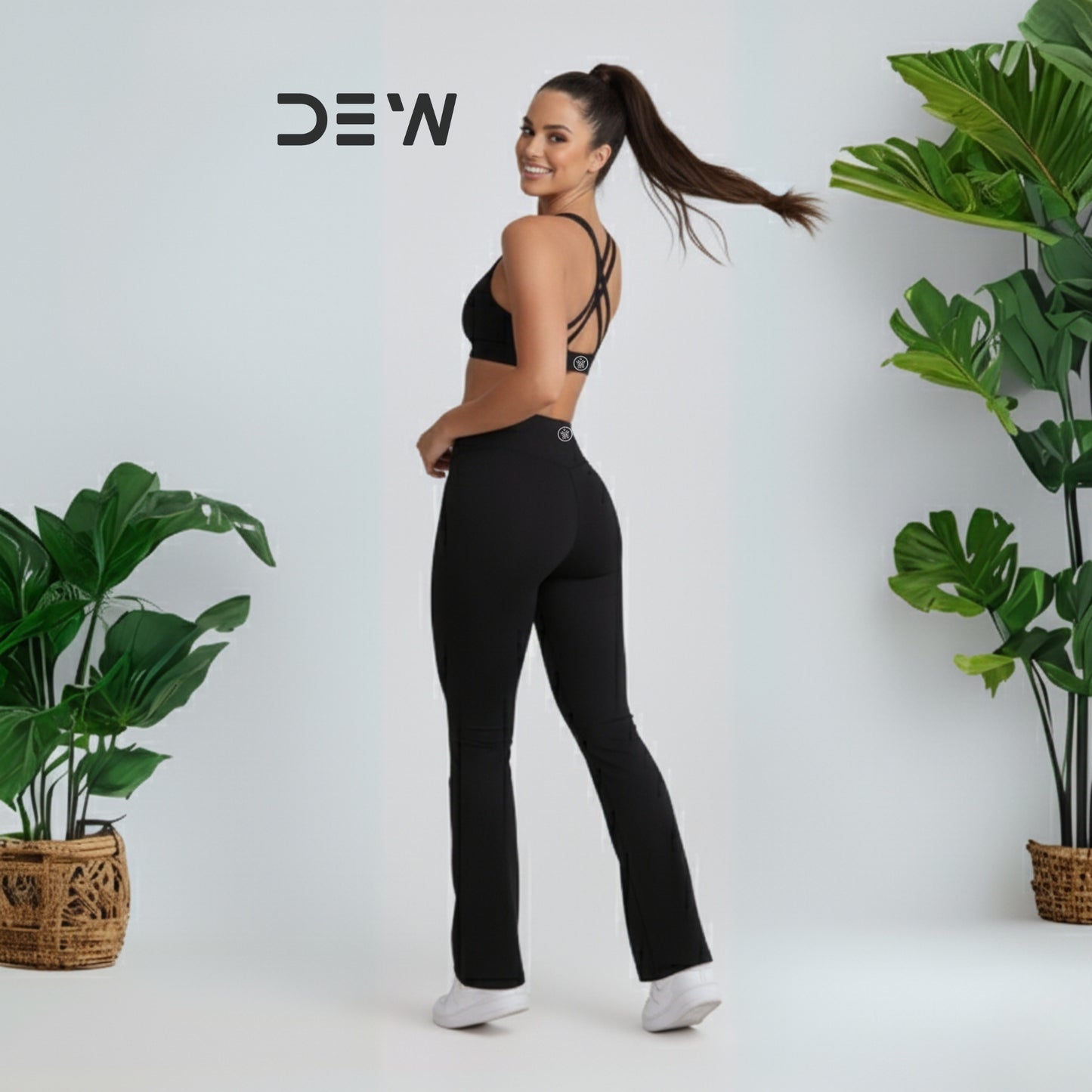 Woman wearing black seamless sports bra and Flow Fit Flare leggings. Minimalist studio setting, highlighting fit and flare design.
