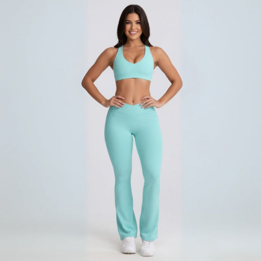 Woman wearing a matching Dew Flow fit flares sports bra and leggings set on a light gray background