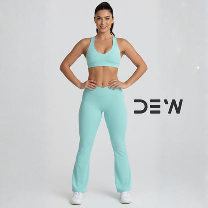 Woman wearing mint seamless sports bra and Flow Fit Flare leggings set. Full body studio shot highlighting flare fit.