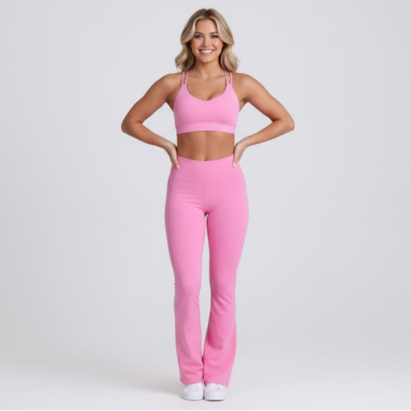 Woman wearing a pink Dew Flow fit flares athletic outfit on a light gray background