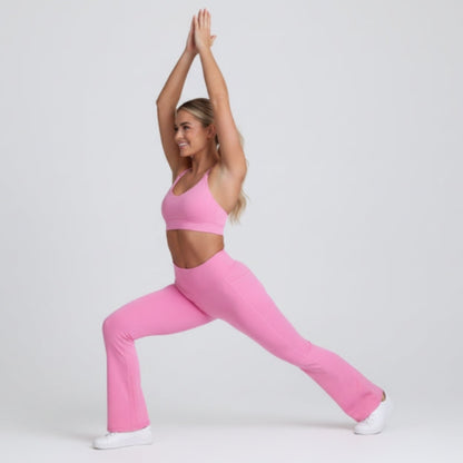 Woman in pink Dew Flow fit flares athletic wear posing against a white background