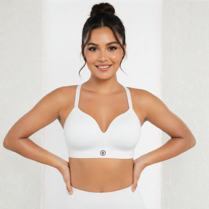 Woman wearing a white sports bra on a plain background