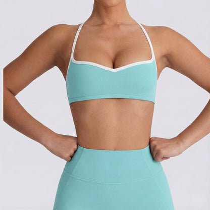 Person wearing a DEW Elevate sports bra and leggings on a light gray background